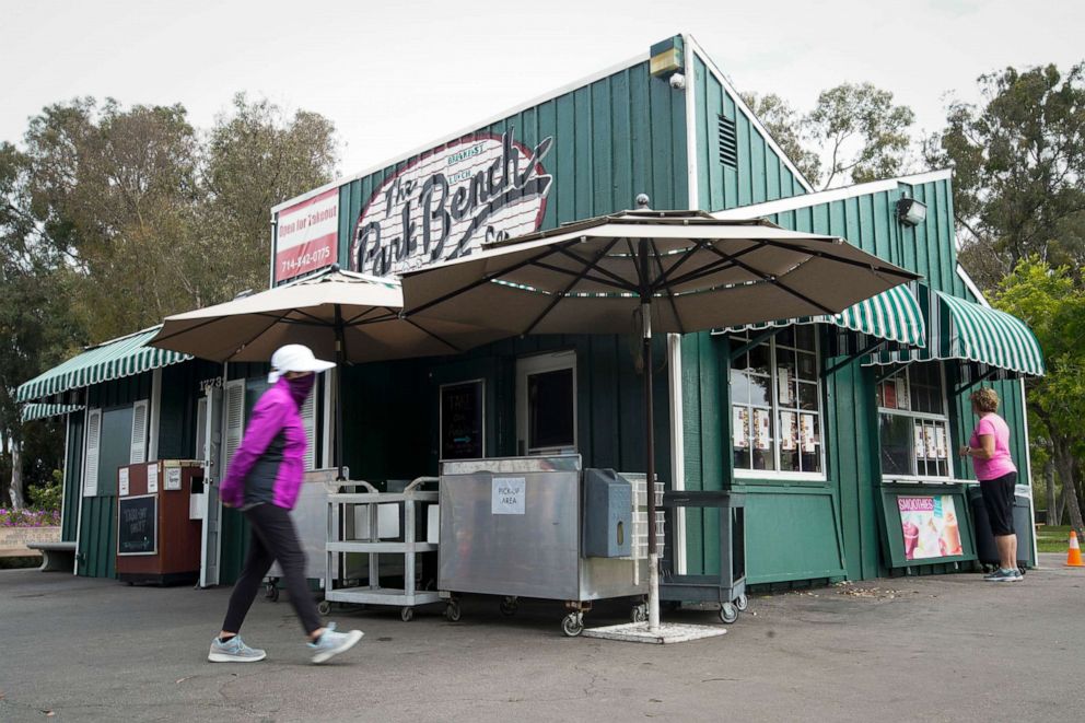 PHOTO: Customers wait for their order outside at the Park Bench Cafe, May 12, 2020, in Huntington Beach, Calif. California restaurants waiting for permission to reopen have been preparing for the "new normal" in the age of the coronavirus.