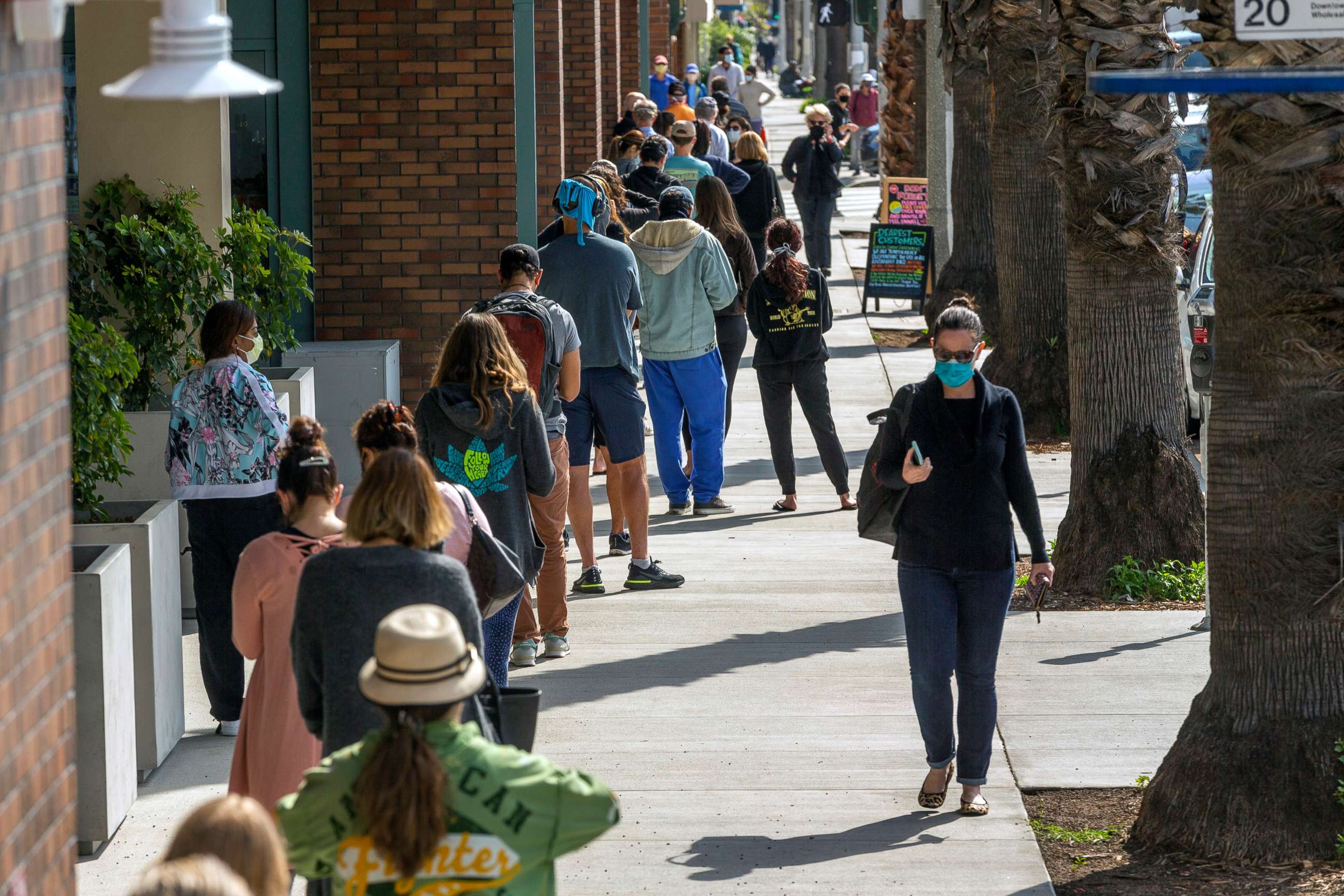 PHOTO: People line up outside a grocery store using social distancing guidelines in Santa Monica, Calif., April 13, 2020. 