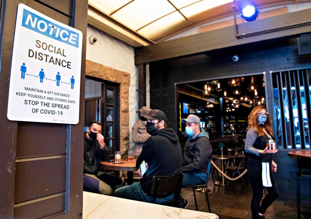 PHOTO: A notice inviting patrons to social distance is seen in the outdoor seating area of The Abbey Food & Bar on Jan. 29, 2021, in West Hollywood, Calif.