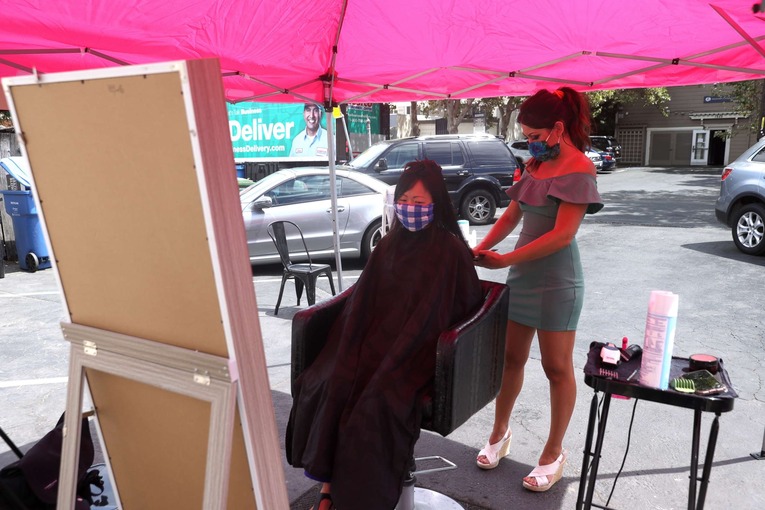 PHOTO: Insignia Hair Salon stylist Regina Muslimova gives a haircut in the parking lot behind the salon, July 21, 2020, in Walnut Creek, California.