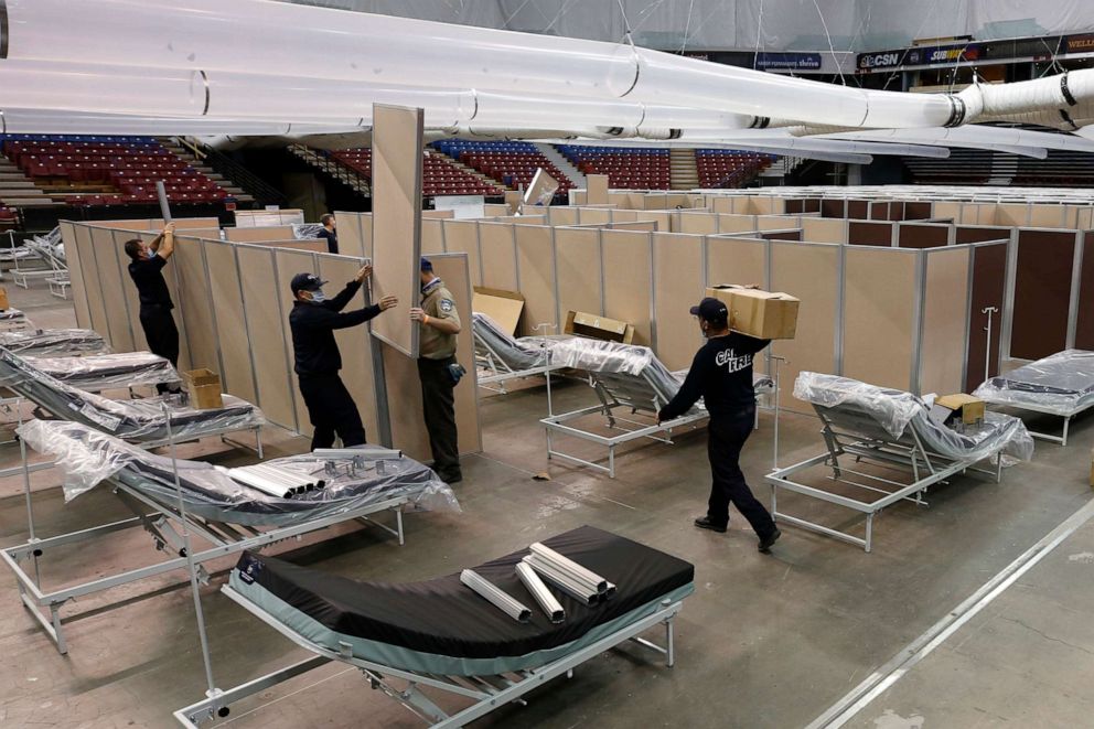 PHOTO: Partitions are installed between beds as work is performed to turn Sleep Train Arena in Sacramento, Calif., into a 400-bed emergency field hospital to help deal with the coronavirus outbreak. 