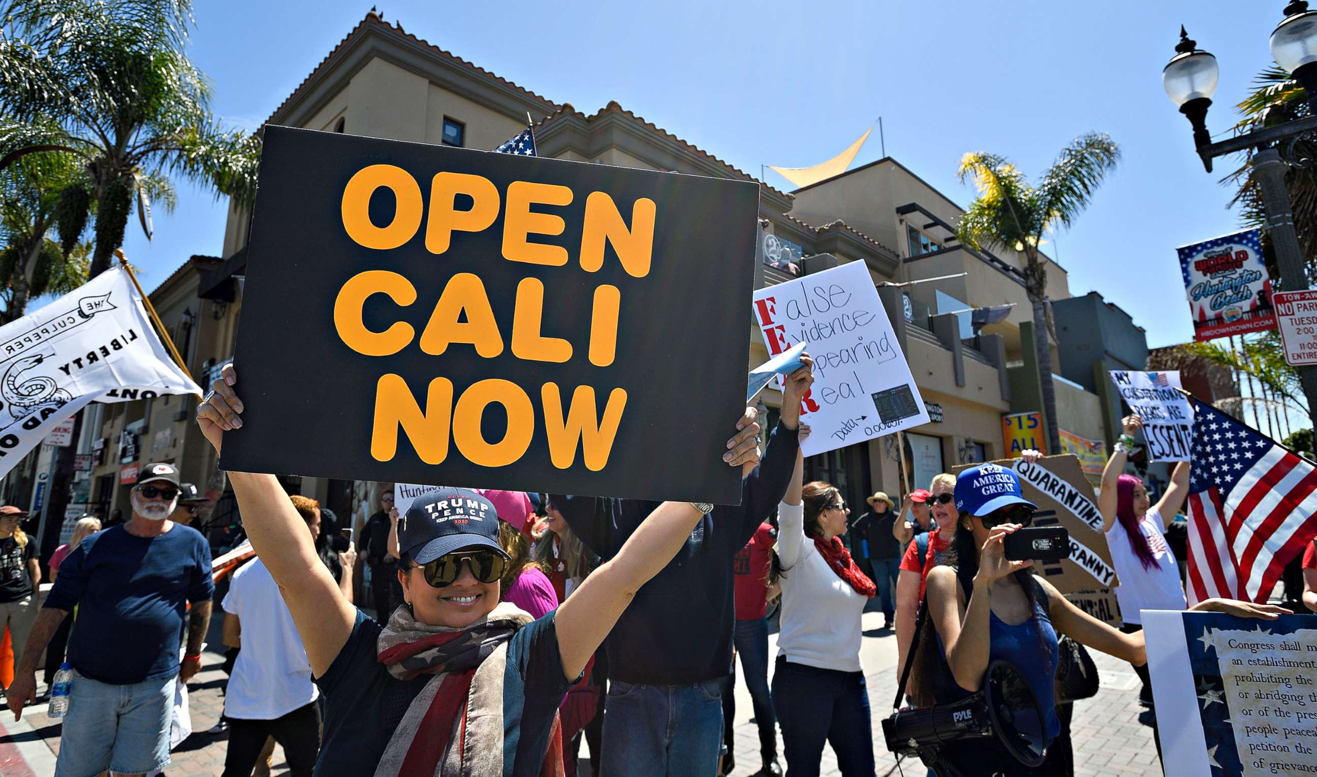 PHOTO: Rose Riggio, from Los Angeles, joins a crowd of people gathered at the corner of Main Street and Walnut Avenue in Huntington Beach, Calif., to protest coronavirus (COVID-19) closures, April 17, 2020.