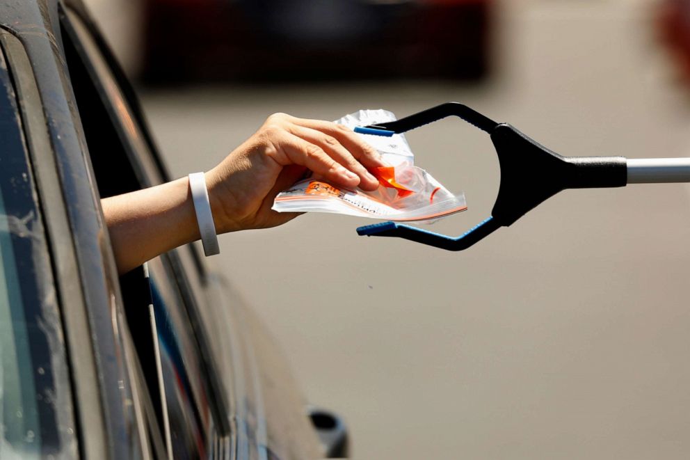PHOTO: A test kit is passed through the car window at the Anaheim Convention Center in Anaheim, Calif, July 11, 2020.