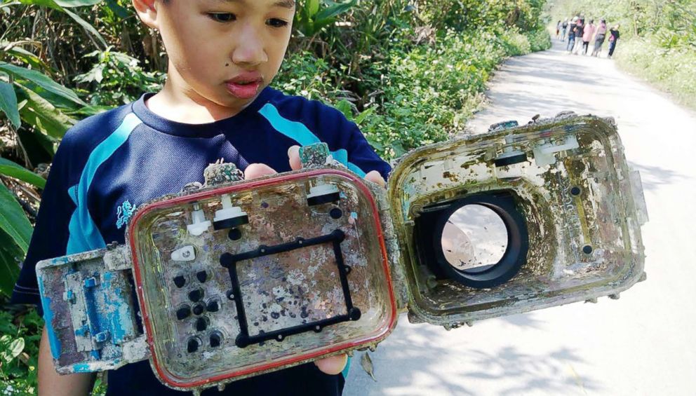 PHOTO: A school pupil displays the barnacle-covered water-proof camera casing which washed up on a beach.