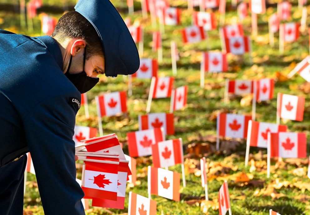 PHOTO: A Canadian service man places Canadian flags on the eve of Remembrance Day at Sunnybrook Veterans Centre as part of its campaign during the COVID-19 pandemic in Toronto, Nov. 10, 2020. The town declared a state of emergency regarding the issue.
