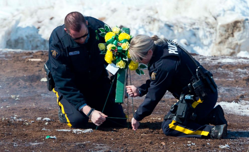 PHOTO: Members of the Royal Canadian Mounted Police lay flowers at the intersection of a crash site near Tisdale, Saskatchewan, April, 8, 2018.