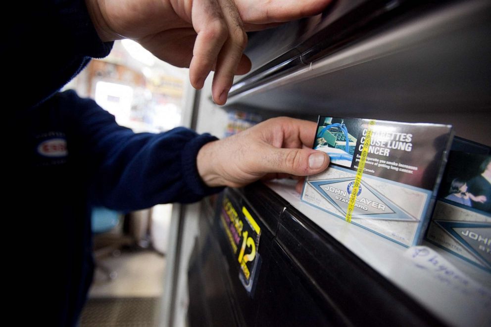 PHOTO: In this file photo, a corner store owner in St. Thomas, Ontario, Canada, holds a package of cigarettes on March 12, 2012.