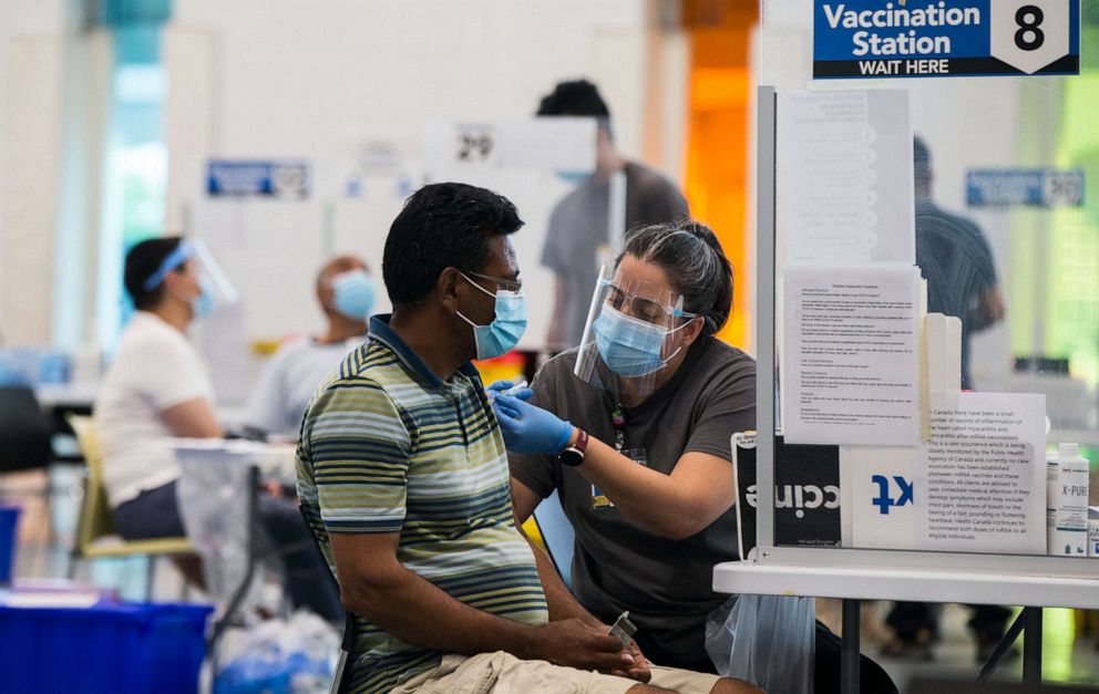 PHOTO: A staff member administers a COVID-19 vaccine to a man at a vaccination clinic at Save Max Sports Center in Brampton, Ontario, Canada, on July 10, 2021