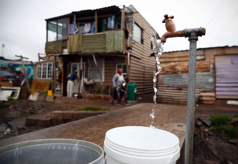 PHOTO: Drinking water is collected from a communal municipal tap in Masiphumelele informal settlement outside Cape Town, South Africa, Jan. 30, 2018.