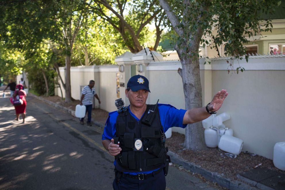 PHOTO: A police officer controls water collection at a source of natural spring water in Cape Town, Feb. 1, 2018.