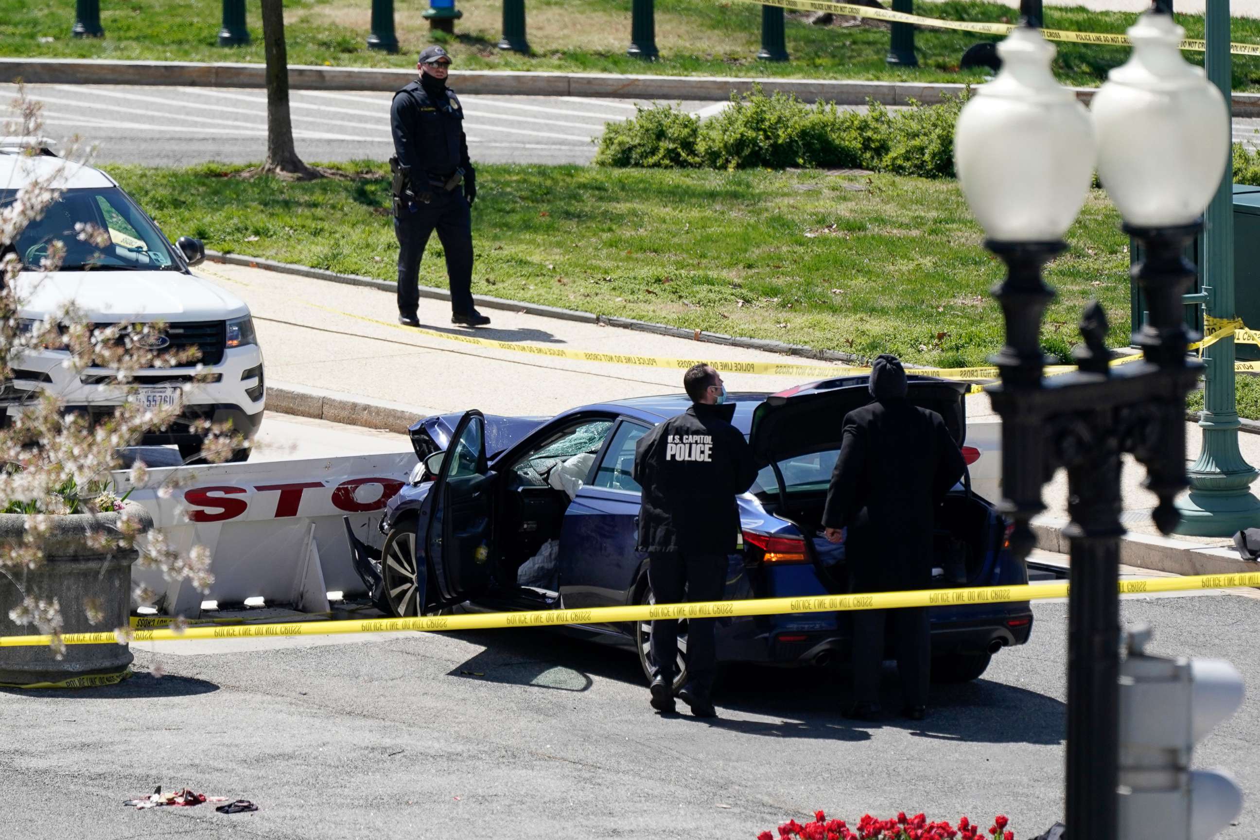 PHOTO: U.S. Capitol Police officers stand near a car that crashed into a barrier on Capitol Hill in Washington on April 2, 2021.