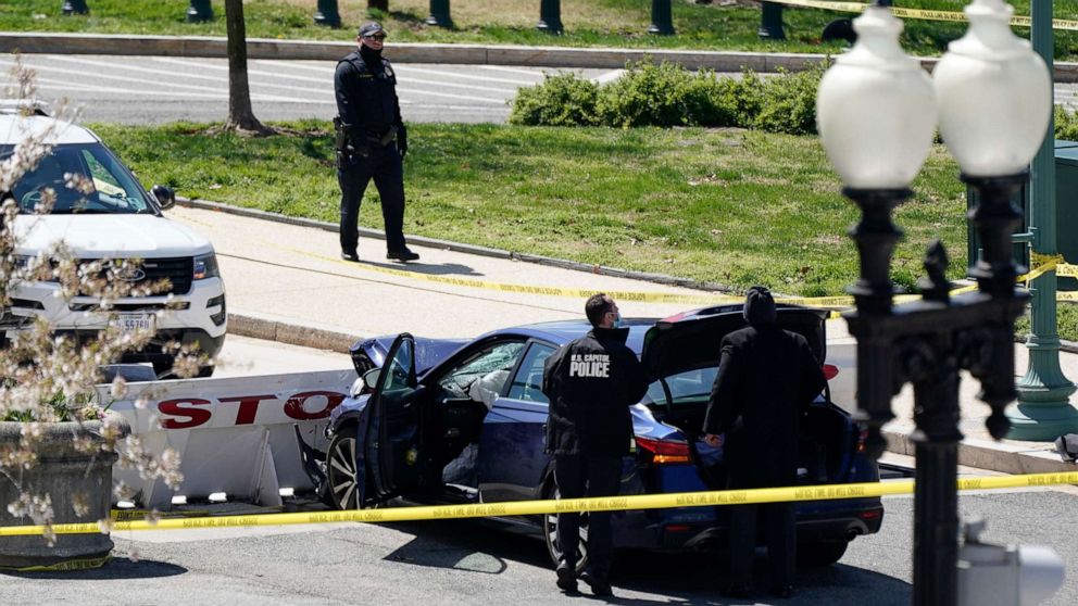 PHOTO: U.S. Capitol Police officers stand near a car that crashed into a barrier on Capitol Hill in Washington on April 2, 2021.