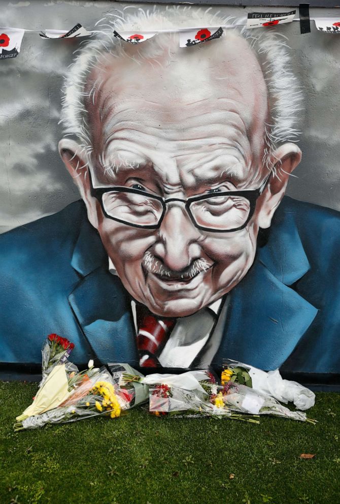 PHOTO: Flowers lie along a mural of late record-breaking centenarian Captain Tom Moore, who died on Feb. 2, 2021, in Two Gates, Tamworth, Britain Feb. 3, 2021.