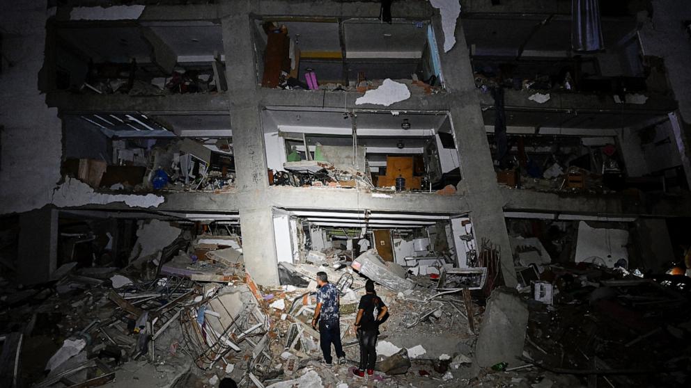 PHOTO: People stand in the rubble near a damaged building following an earthquake in Catia La Mar, La Guaira State, some 30kms north-west of Caracas, early on June 25, 2026. 