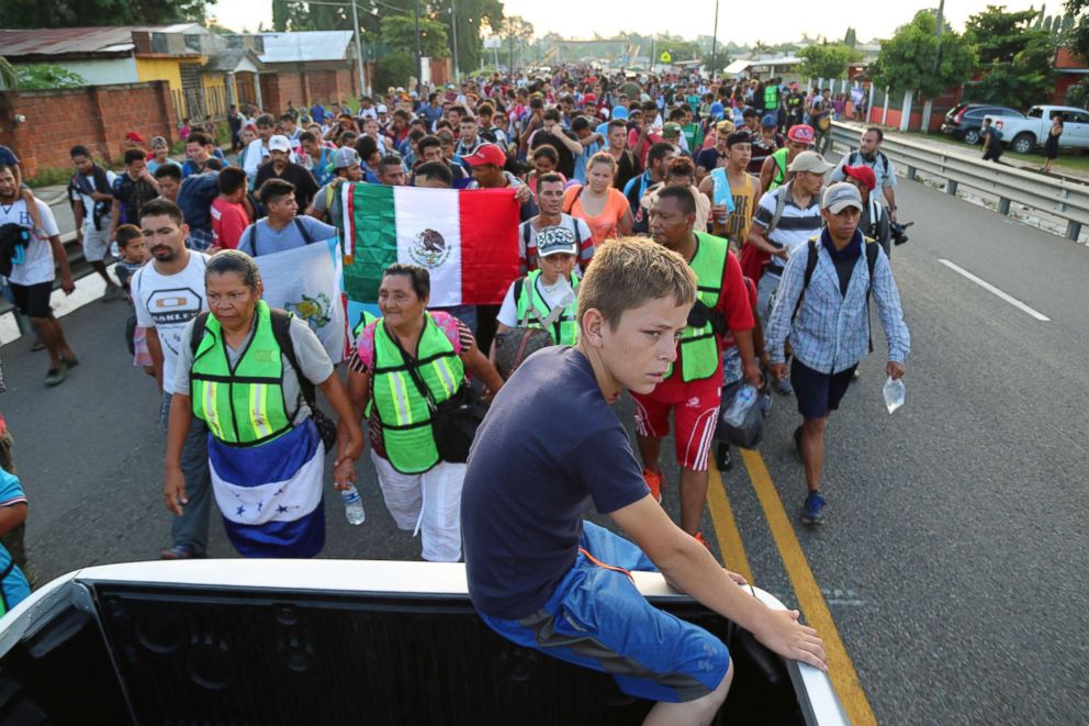 PHOTO: A migrant child barely able to continue onward jumps onto a truck to rest during the caravan to Tapachula, Mexico.