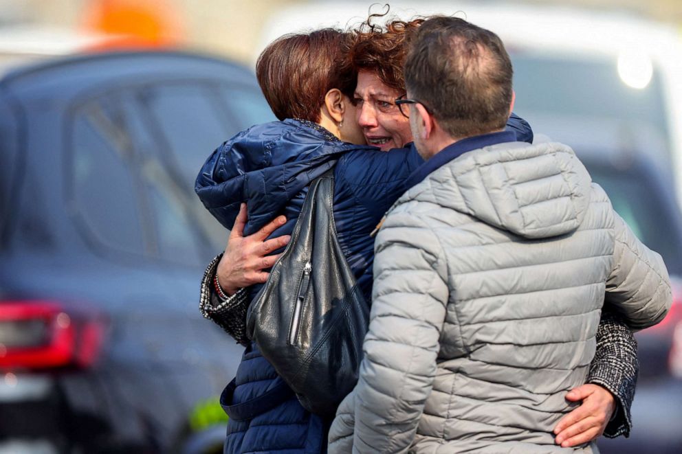 PHOTO: Women embrace each other after a vehicle drove into a group at a Belgian carnival in the village of Strepy-Bracquegnies, Belgium, March 20, 2022.
