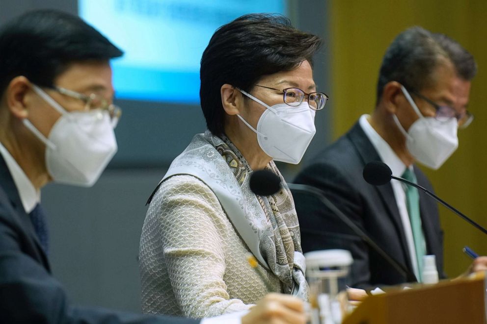 PHOTO: Hong Kong Chief Executive Carrie Lam, center, Chief Secretary, John Lee, left, and Financial Secretary, Paul Chan, right,  listen to reporters' questions during a press conference on March 21, 2022 in Hong Kong, China.