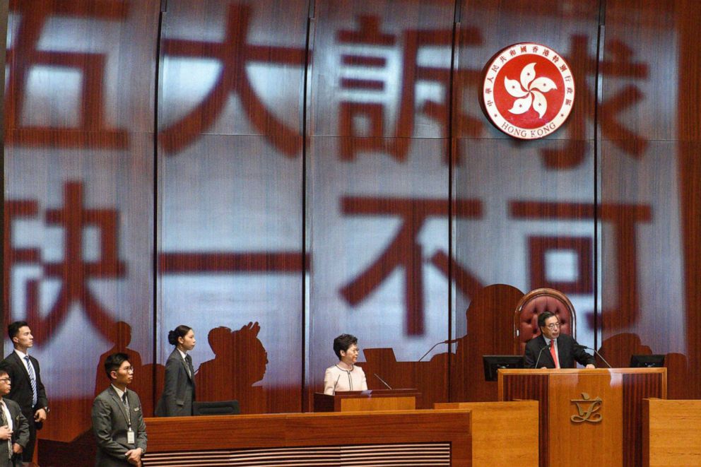 PHOTO: The words 'Five demands, not one less' are projected onto the wall behind Hong Kong's Chief Executive Carrie Lam (2-R) as she arrives to deliver her annual policy address at the Legislative Council in Hong Kong on Oct. 16, 2019.