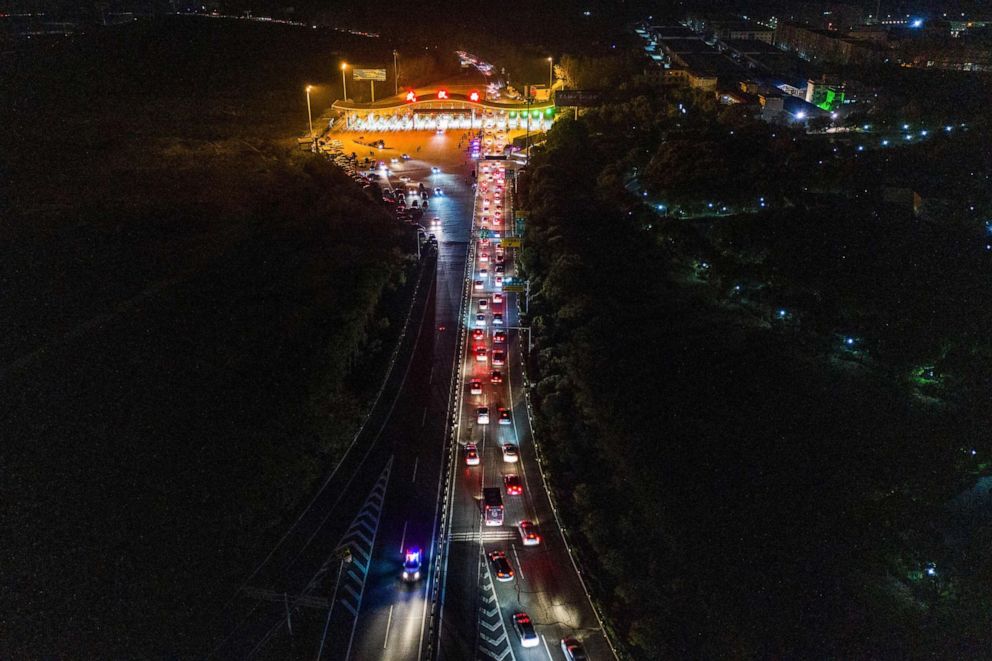 PHOTO: This aerial photo taken early on April 8, 2020, shows cars queueing at a highway toll station in Wuhan in China's central Hubei province as they prepare to leave the city after authorities lifted a monthslong ban on outbound travel.