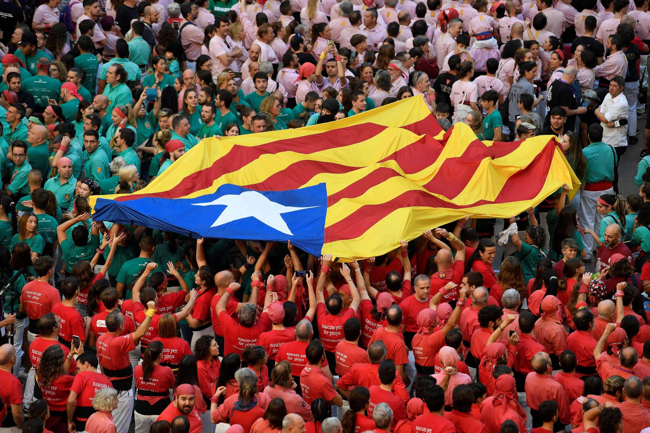 PHOTO: Teams members hold a Catalan pro-independence Estelada flag during the 28th edition of the 'human towers' competetion at the Tarraco arena in Tarragona on Oct. 2, 2022.