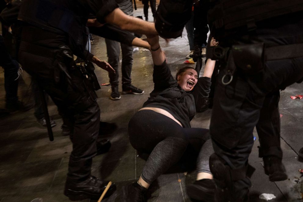 Police officers clash with demonstrators outside El Prat airport in Barcelona, Spain, Monday, Oct. 14, 2019.