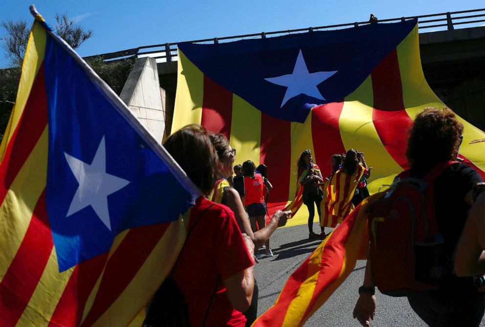 PHOTO: Demonstrators hold Catalan pro-independence "Estelada" flags as they march on the Nacional 2 road in Sils, near Girona, Oct. 16, 2019, a day after police arrested 51 people across Catalonia.