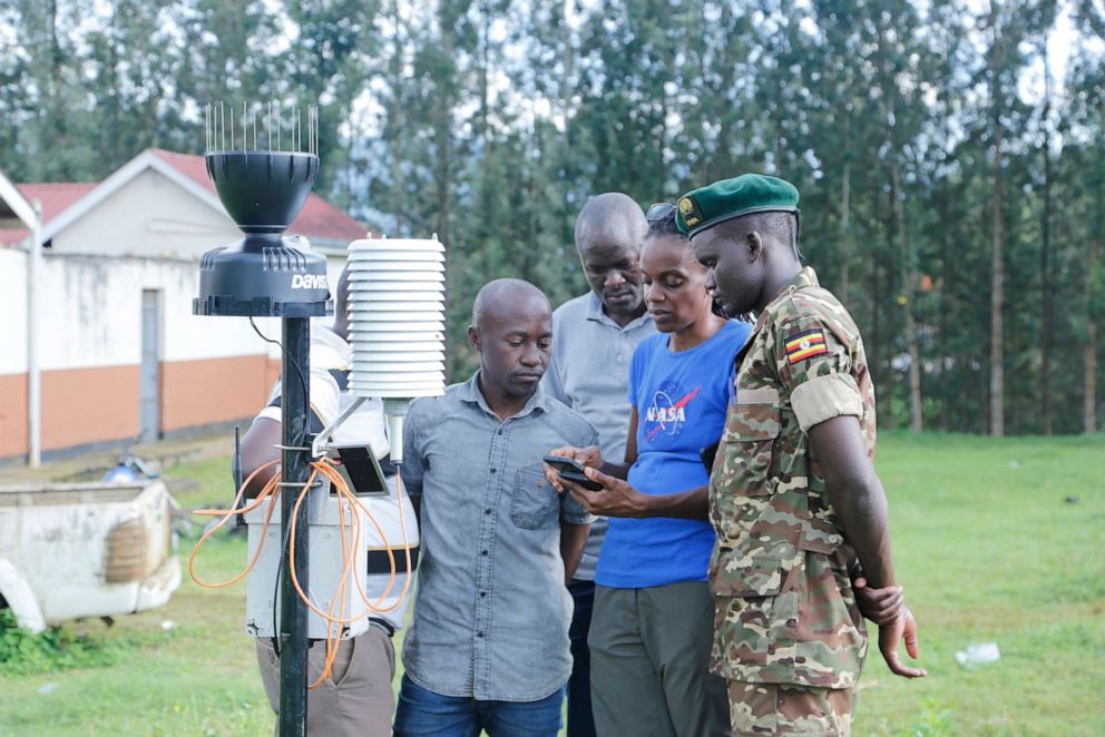 PHOTO: Dr. Catherine Nakalembe demonstrates field data collection with local officials and government staff in Uganda.