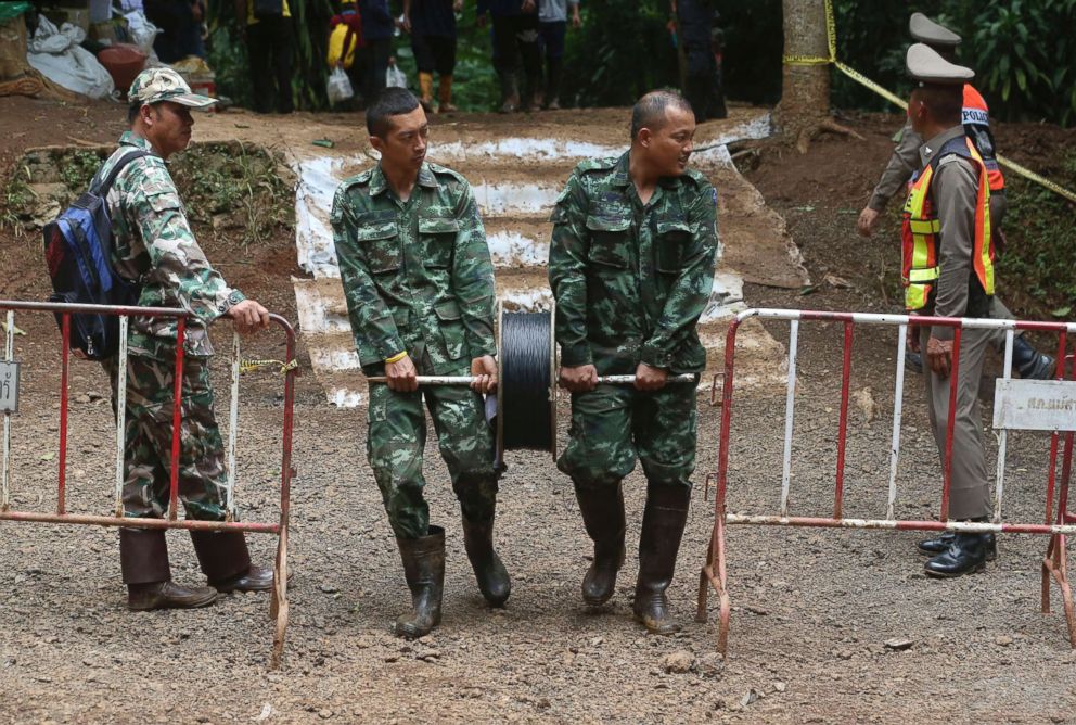 PHOTO: Rescuers lay telephone cable from a cave where a young soccer team and their coach are trapped Thursday, July 5, 2018, in Mae Sai, Chiang Rai province, northern Thailand.