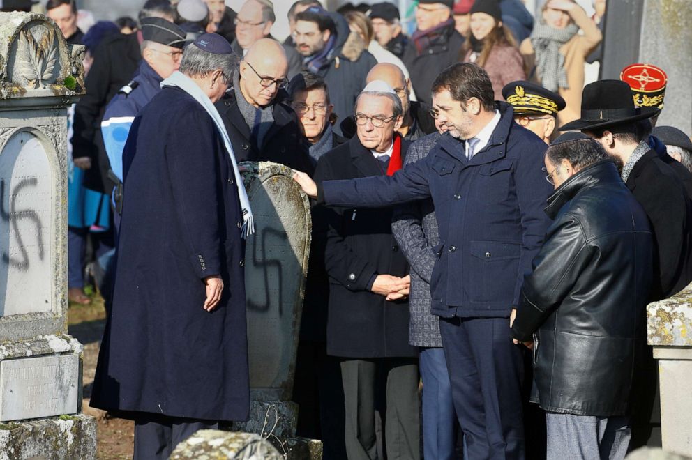 PHOTO: French Interior Minister Christophe Castaner touches a headstone during a visit to the Jewish cemetery in Westhoffen, near Strasbourg, France after the graves were desecrated with swastikas. 