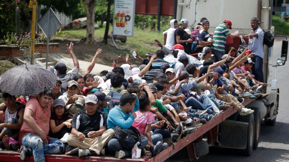 PHOTO: Honduran migrants who are traveling to the United States as a group, get a free ride in the back of a trailer truck flatbed, as they make their way through Teculutan, Guatemala, Oct. 17, 2018.