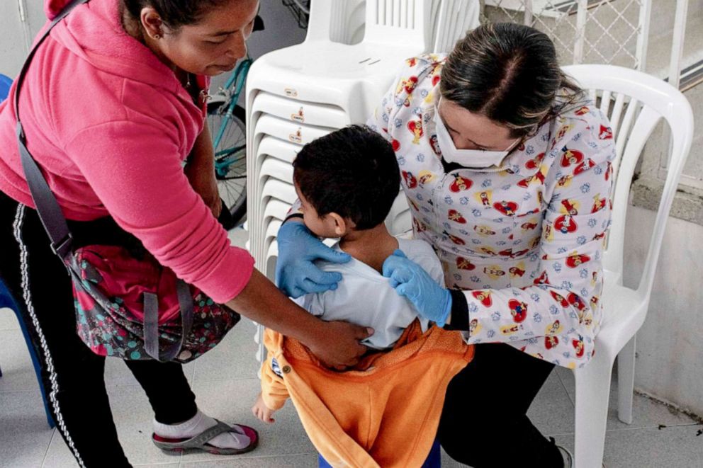 PHOTO: A mother oversees her son getting a health checkup from a nurse at El Centro Abrazar in Bogota, Jan. 20, 2020.