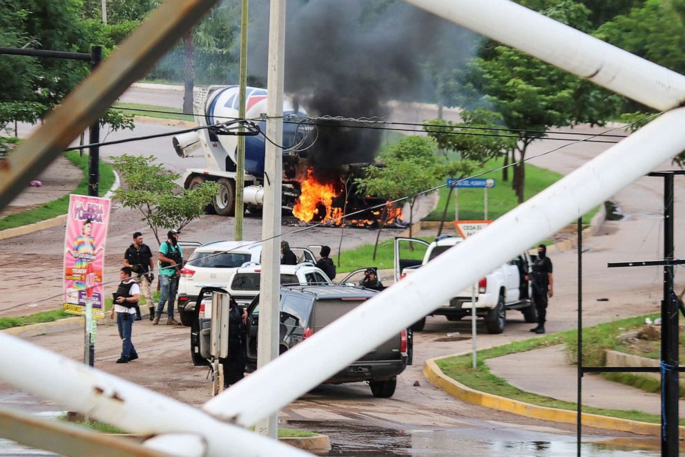 PHOTO: Cartel gunmen are seen near a burning truck  during clashes with federal forces following the detention of Ovidio Guzman, son of drug kingpin Joaquin "El Chapo" Guzman, in Culiacan, Sinaloa state, Mexico, Oct. 17, 2019.