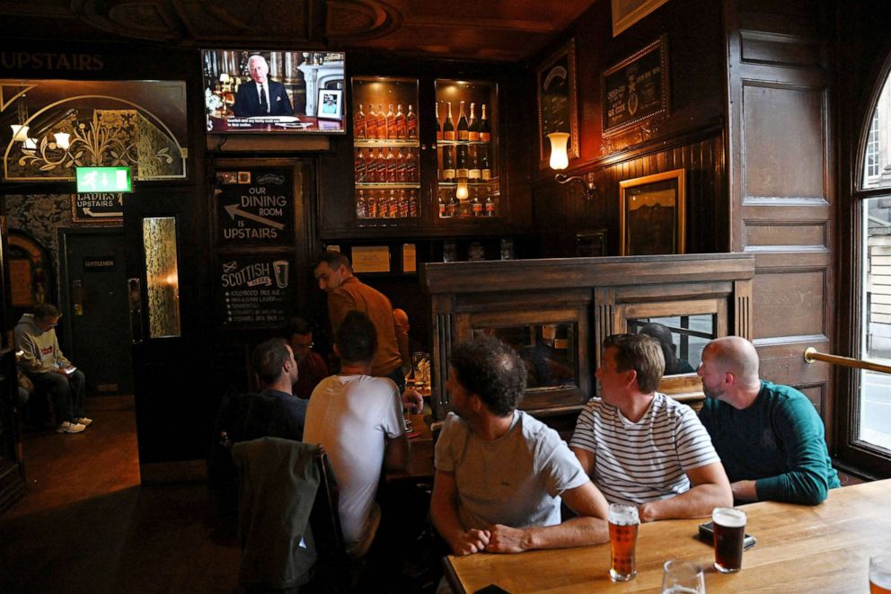 PHOTO: Drinkers in Deacon Brodies Tavern in Edinburgh watch a televised address from Britain's King Charles III, made from the Blue Drawing Room at Buckingham Palace in London on Sept. 9, 2022.