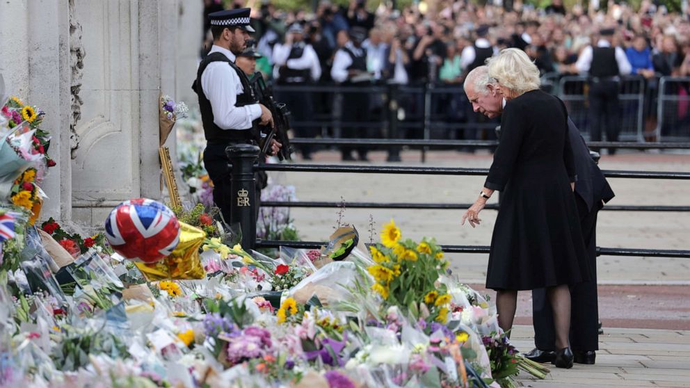 PHOTO: King Charles III and Camilla, Queen Consort view floral tributes to the late Queen Elizabeth II outside Buckingham Palace on Sept. 9, 2022 in London.