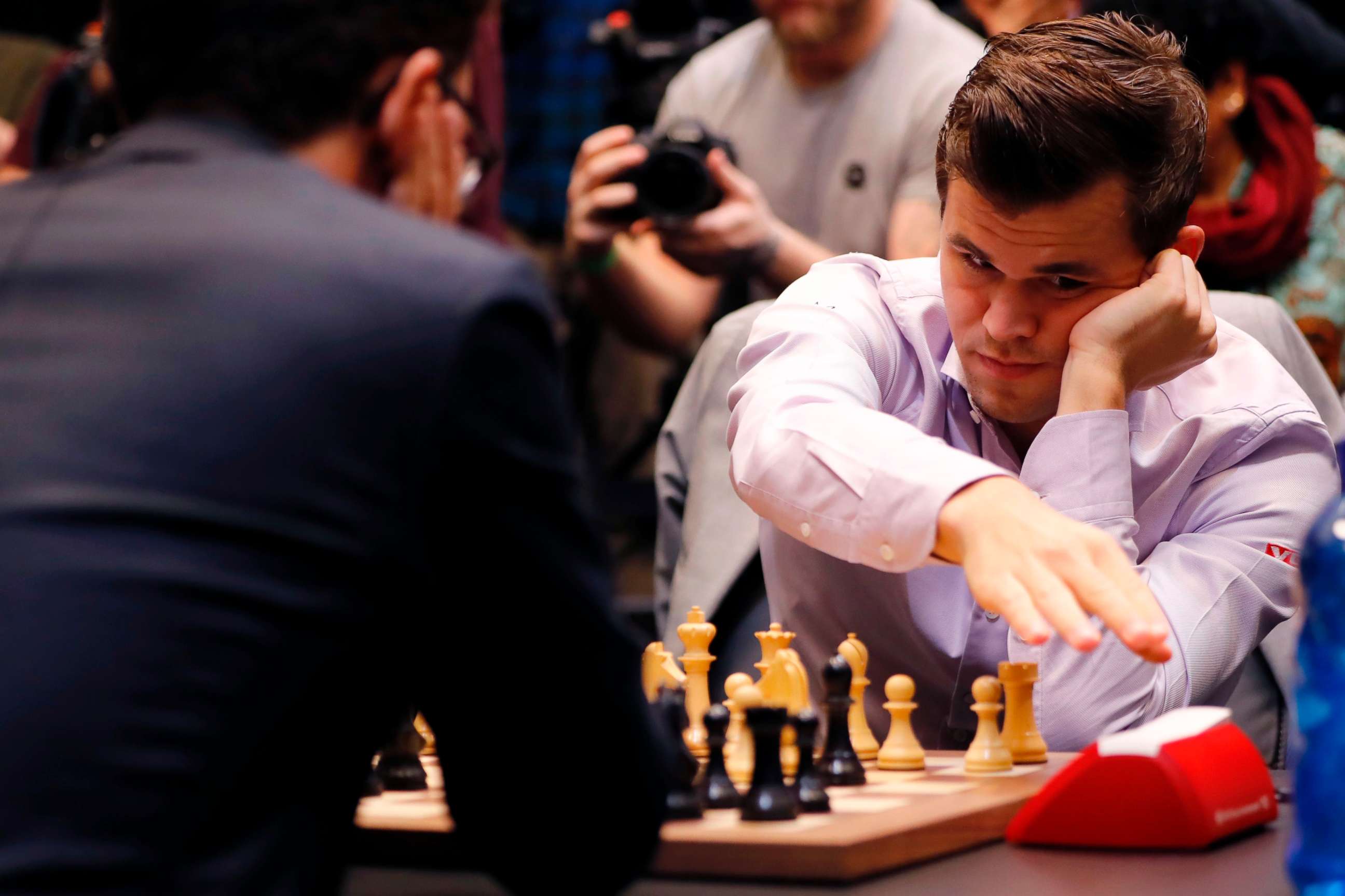 PHOTO: Reigning world chess champion Norway's Magnus Carlsen hits the clock as he plays in the tie-break matches of the 2018 World Chess Championship against challenger, U.S. player Fabiano Caruana in London on Nov. 28, 2018.