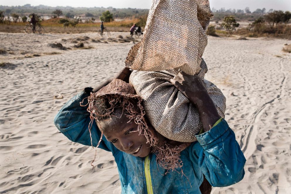 PHOTO: An undated photo shows Daniel, 11, carrying a bag of cobalt on his back in Kolwezi, D.R.C. He works in a mine ferrying sacks of cobalt to a depot."n"nCobalt is a vital mineral needed for the production of rechargeable batteries.