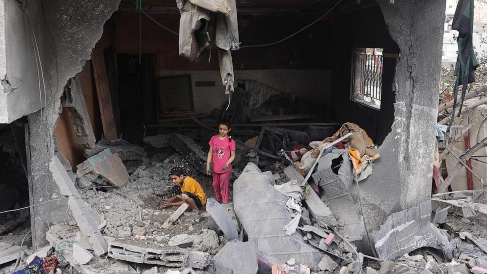 PHOTO: Palestinians children search through the rubble of their home a day after an operation by the Israeli Special Forces in the Nuseirat camp, in the central Gaza Strip on June 9, 2024.