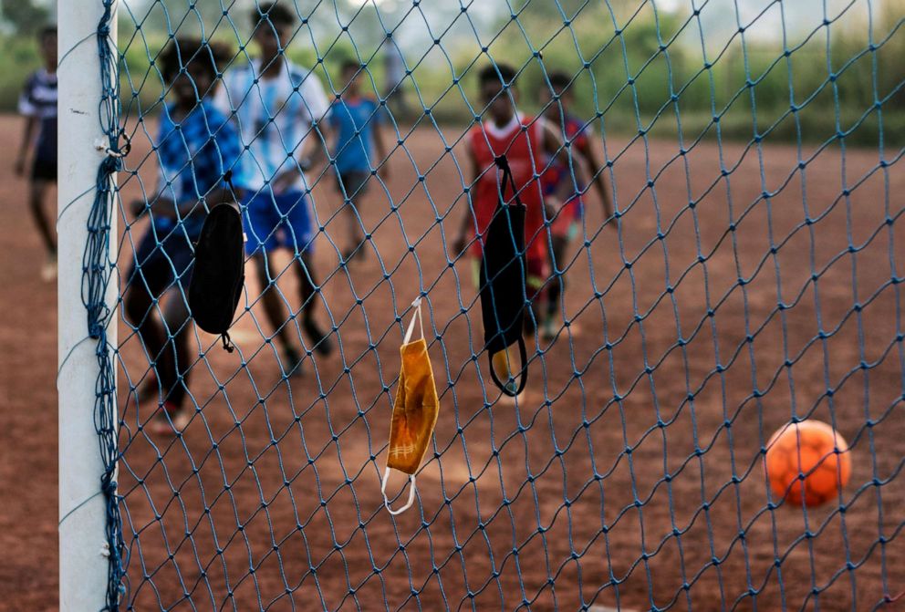 PHOTO: Children hang their face masks in the nets and play a game of soccer in Kochi, Kerala state, India, on Oct. 6, 2020, amid the coronavirus pandemic.