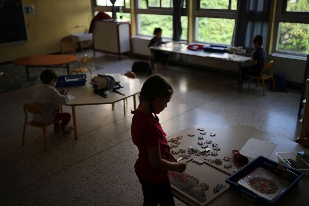 PHOTO: Children respecting social distance play with jigsaw puzzles in a classroom of the Saint-Tronc Castelroc primary school in Marseille, southern France, on May 14, 2020.