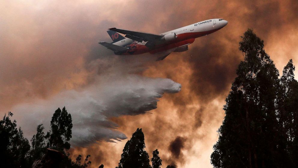 PHOTO: A 10 Tanker DC-10 fire plane throws water over a forest fire in Ninhue, Ãuble Region, in Chile, on February 10, 2023. - Forest fires have raged for more than a week in south-central Chile, leaving at least 24 people dead.