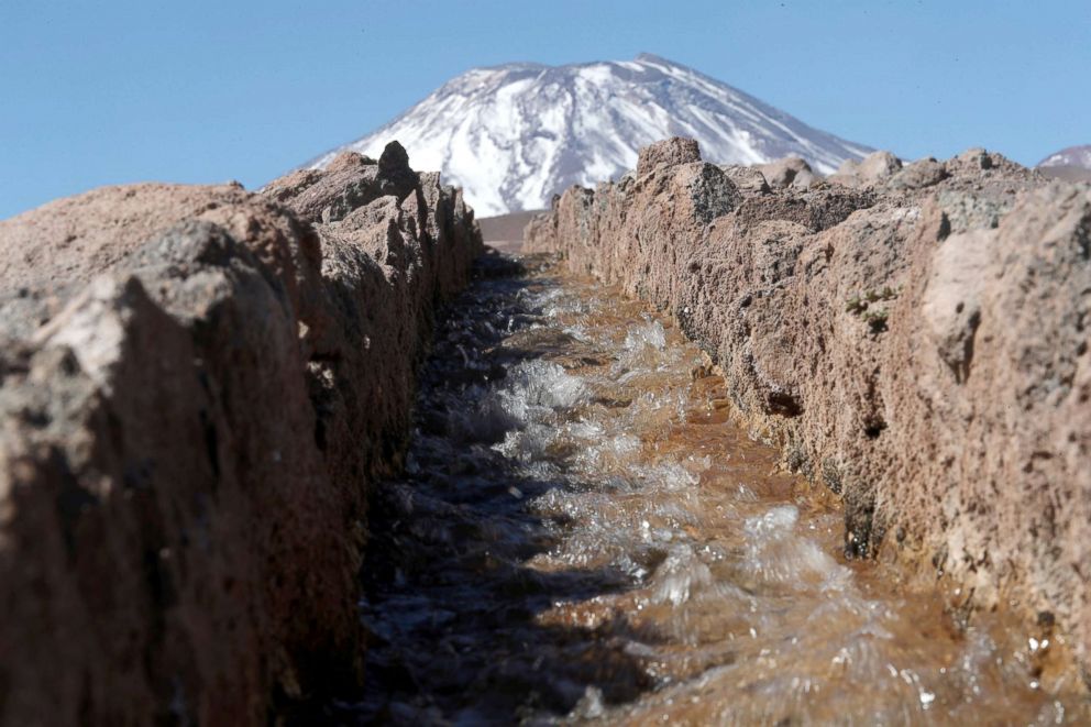 PHOTO: Water flows in an irrigation canal in front of Lascar volcano in the Talabre area at Atacama salt flat in the Atacama desert, Chile, Aug. 16, 2018.