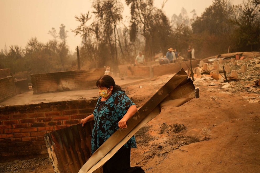 PHOTO: A woman clears debris from a landscape of charred remains in Santa Ana, Chile, on Feb. 4, 2023.