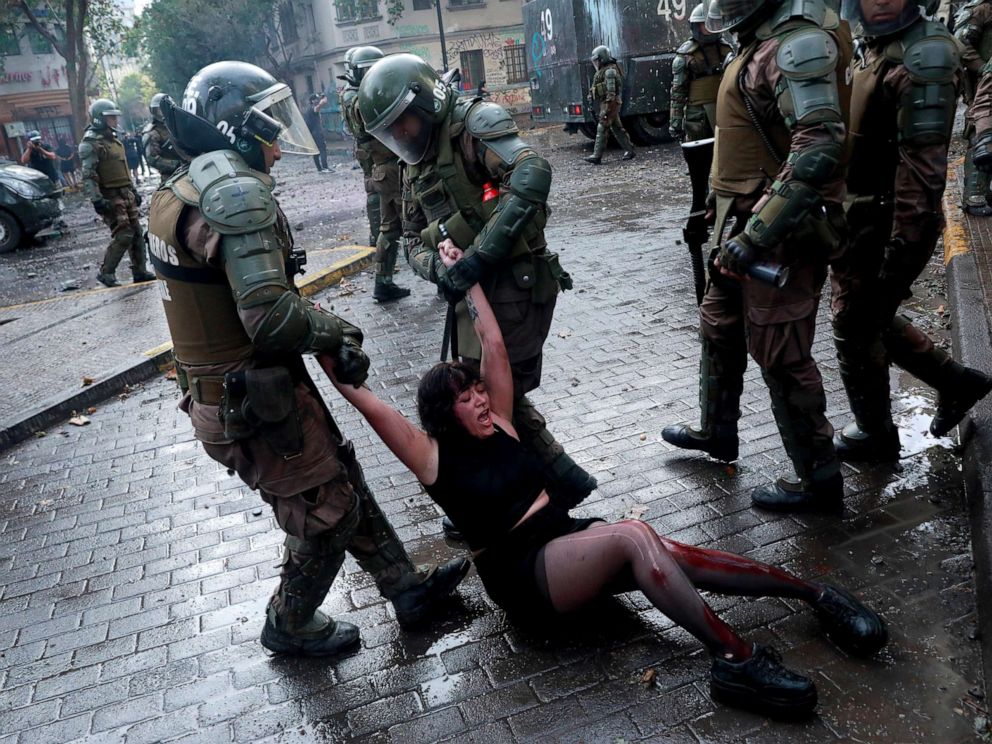 PHOTO: Riot police officers detain Camila Miranda after she was shot with 6 rubber bullets, 4 of which pierced her skin during a protest which she was demonstrating at against Chiles government in Santiago, Chile, Nov. 4, 2019.