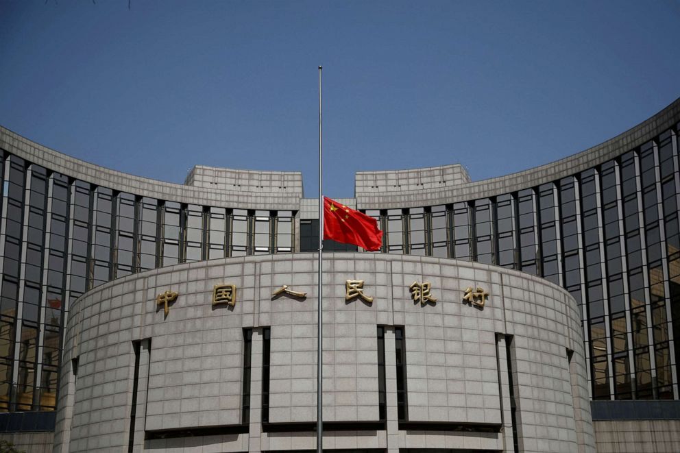 FILE PHOTO: The Chinese national flag flies at half-mast at the headquarters of the People's Bank of China, as China holds a national mourning for those who died of COVID-19, on the Qingming tomb-sweeping festival in Beijing, China April 4, 2020.