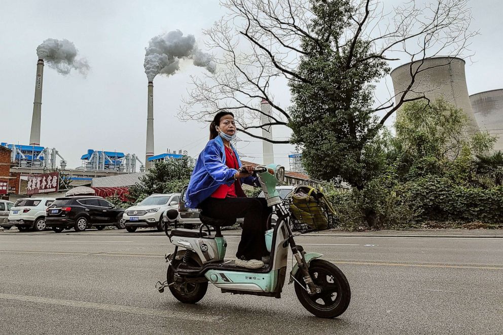 PHOTO: A worker rides past a coal fired power plant, in Hanchuan, Hubei province, China, Oct. 13, 2021.