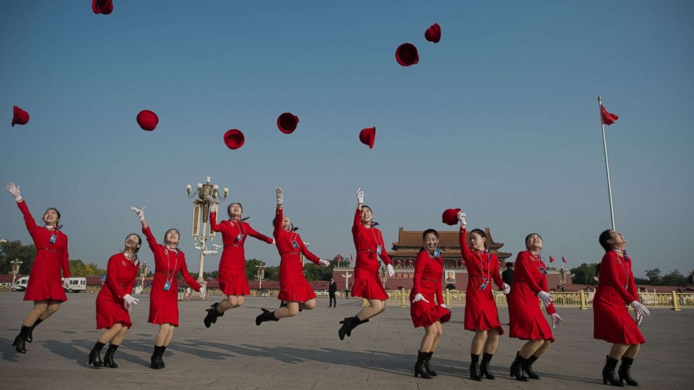 PHOTO: Hostesses jump in the air and throw their hats on Tiananmen square during the closing session of the 19th Communist Party Congress in Beijing, Oct. 24, 2017.