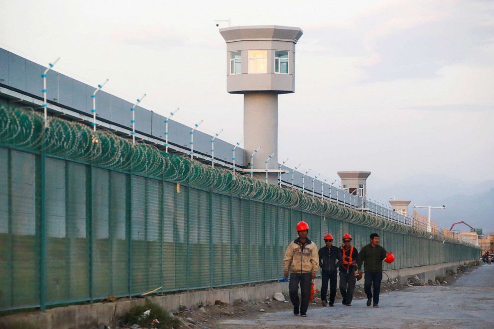 PHOTO: Workers walk by the perimeter fence of what is officially known as a vocational skills education centre in Dabancheng in Xinjiang Uighur Autonomous Region, China Sept. 4, 2018.