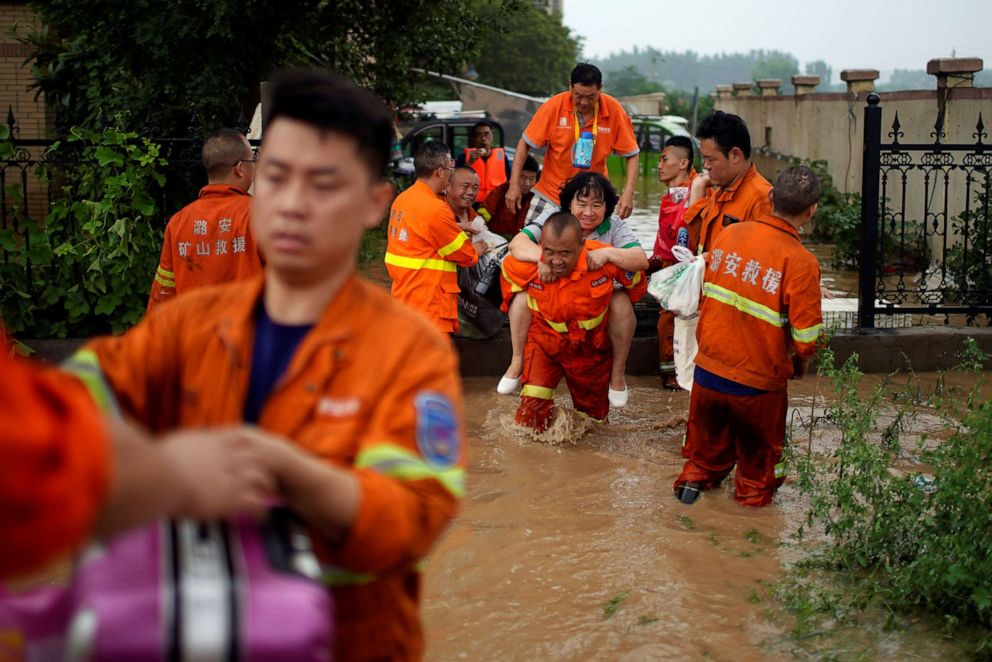 PHOTO: Rescue workers help residents stranded by floodwaters following heavy rainfall in Zhengzhou, Henan province, China July 23, 2021.