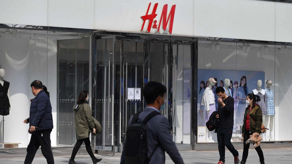 PHOTO: People walk past an H&M store in Beijing on March 25, 2021.