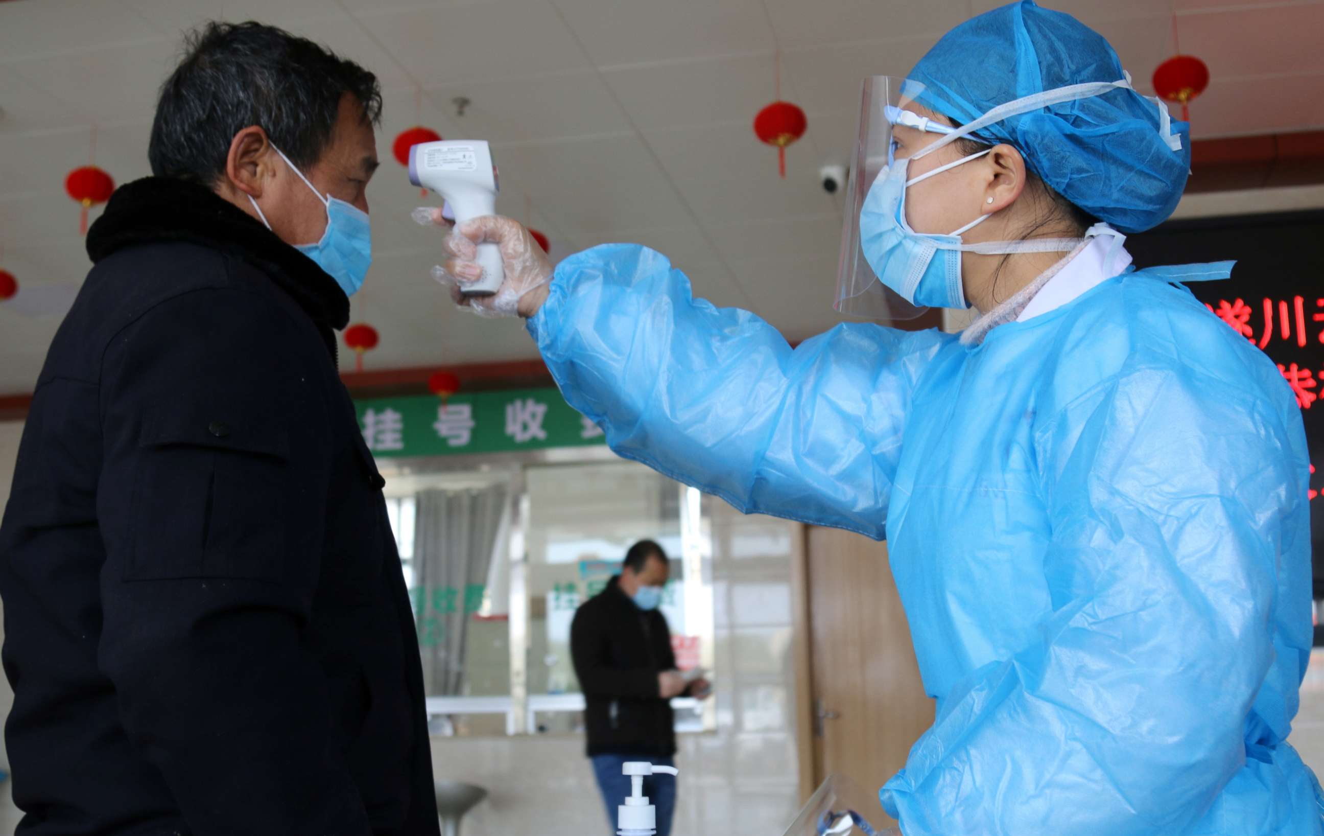 PHOTO: A medical worker takes a man's body temperature at an entrance to a hospital in Suichuan, Jiangxi province, China, on Feb. 2, 2020, as the country is hit by an outbreak of the new coronavirus.